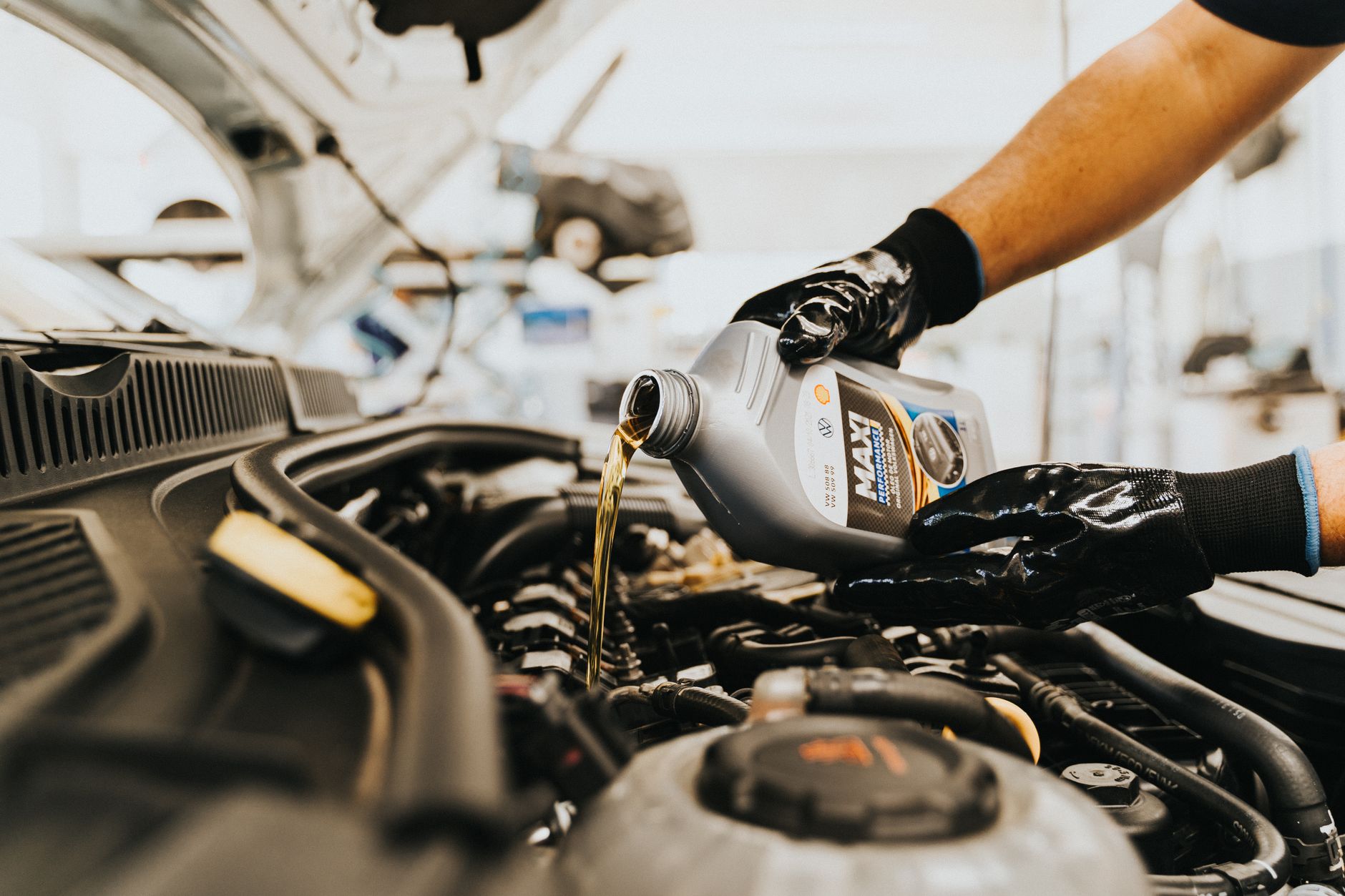 Photo of a mechanic pouring engine oil into a car