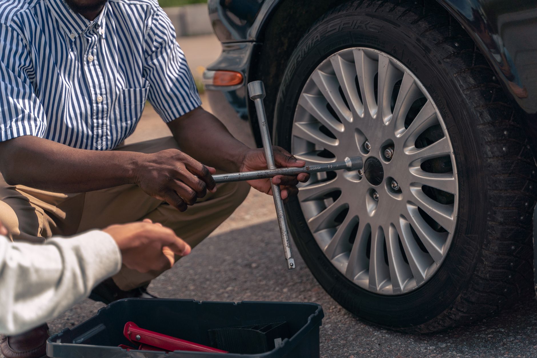 Photo of an adult showing how to change a car tire