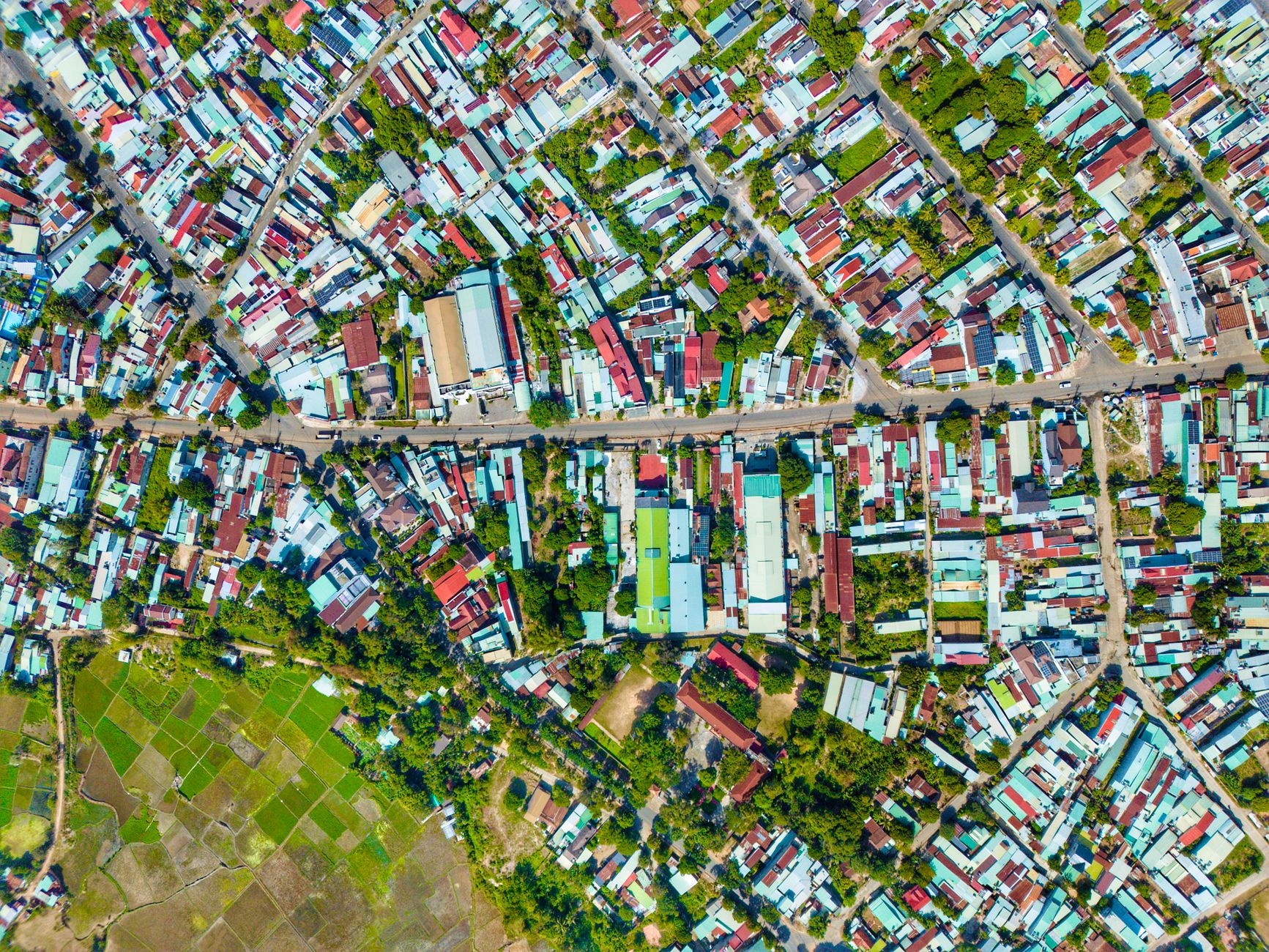 An aerial view of a neighbourhood with closely packed houses and greenery