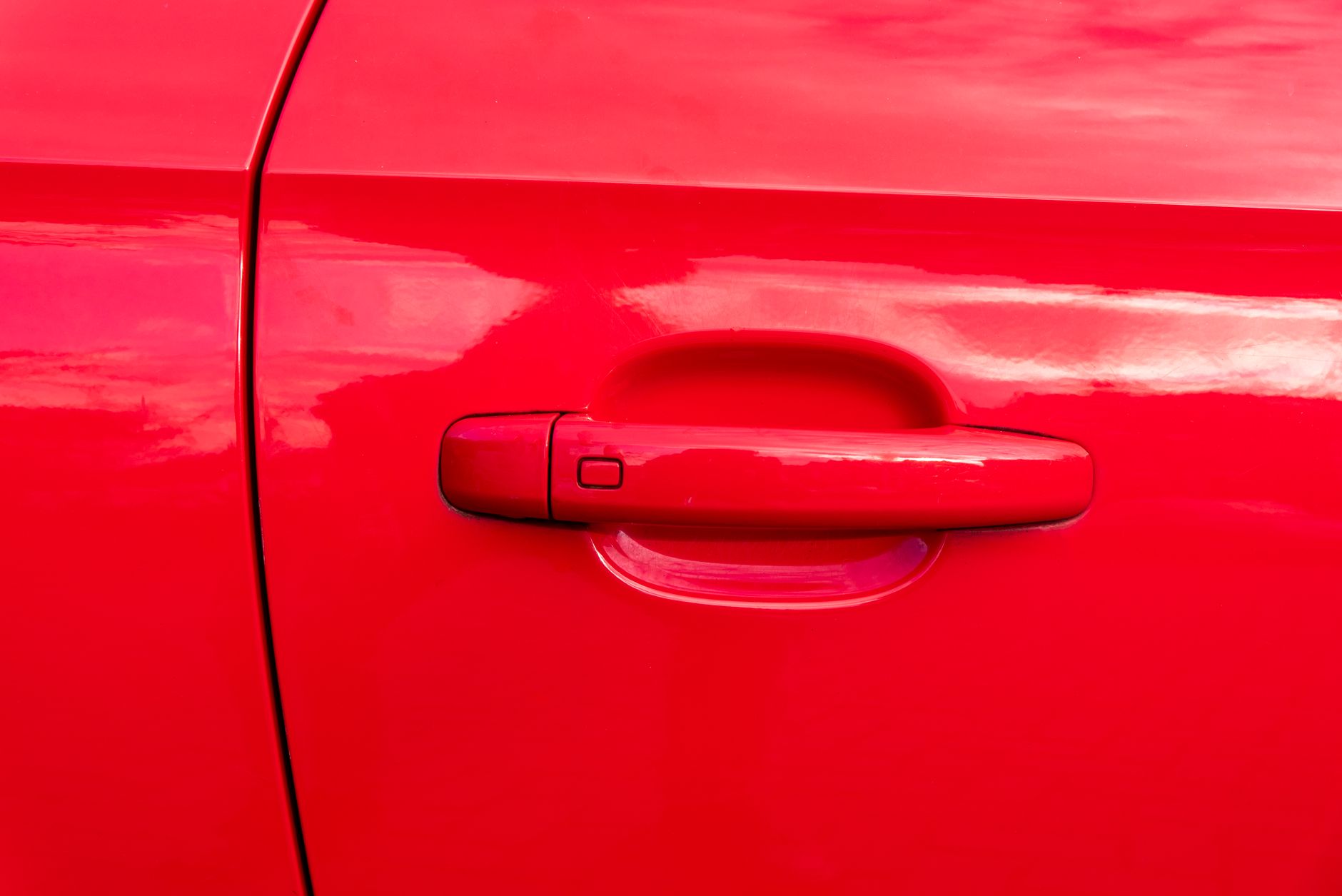 A bright red car door with clean lines