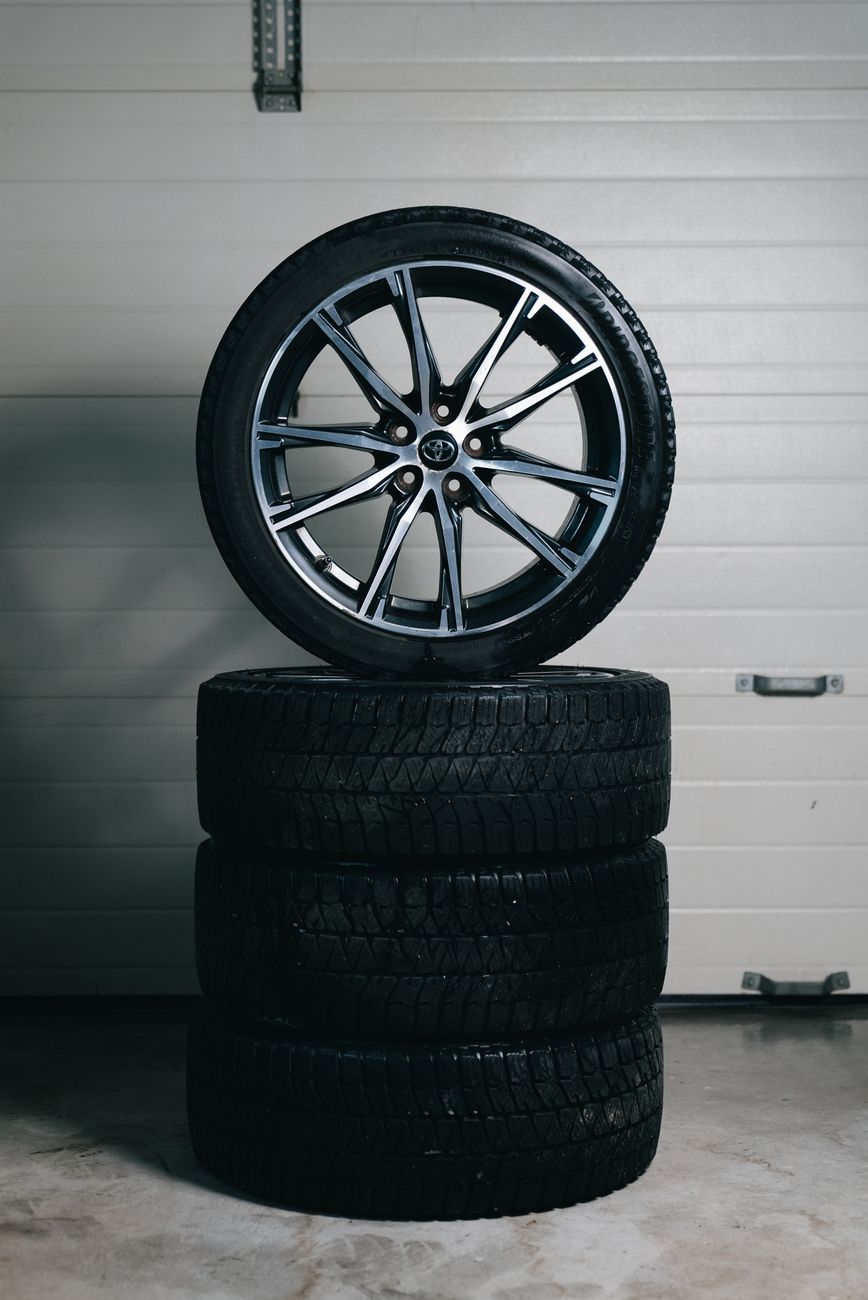 Tyres stacked with an alloy wheel on top in the garage