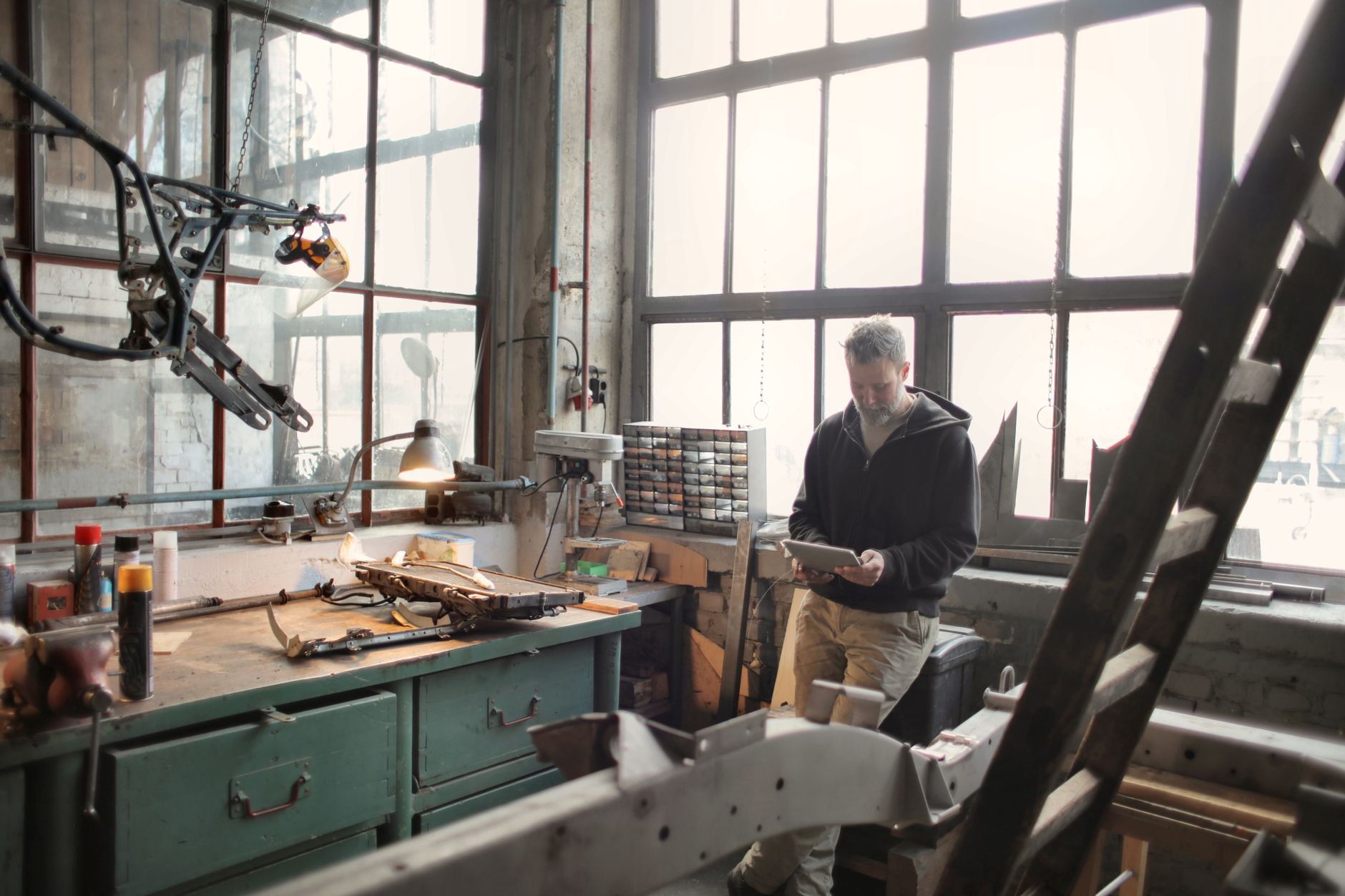 A mechanic checking a tablet beside the workbench