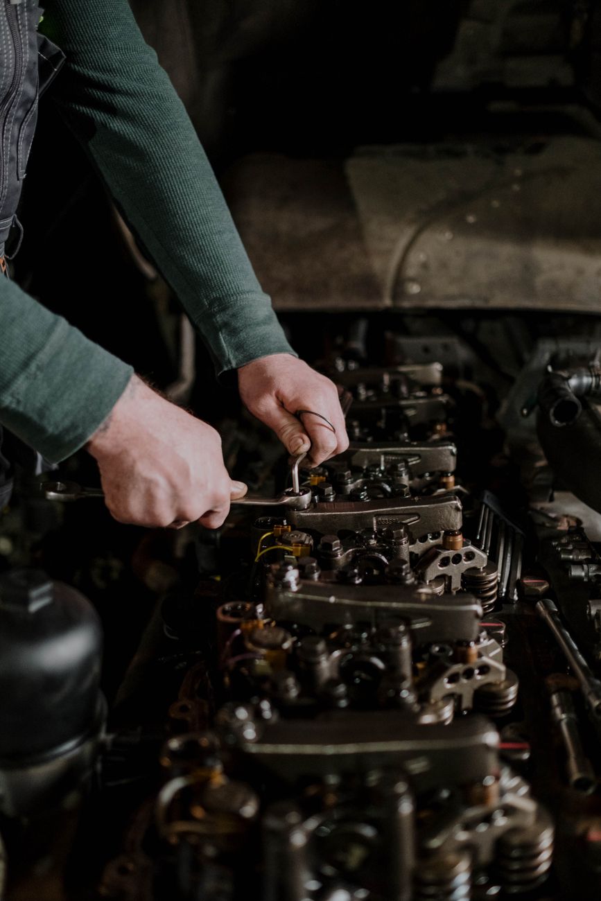 A mechanic's hands using tools to repair an engine