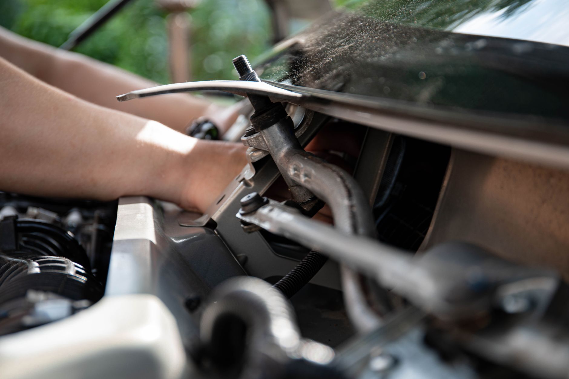 Close view of a mechanic holding a wrench on an engine component