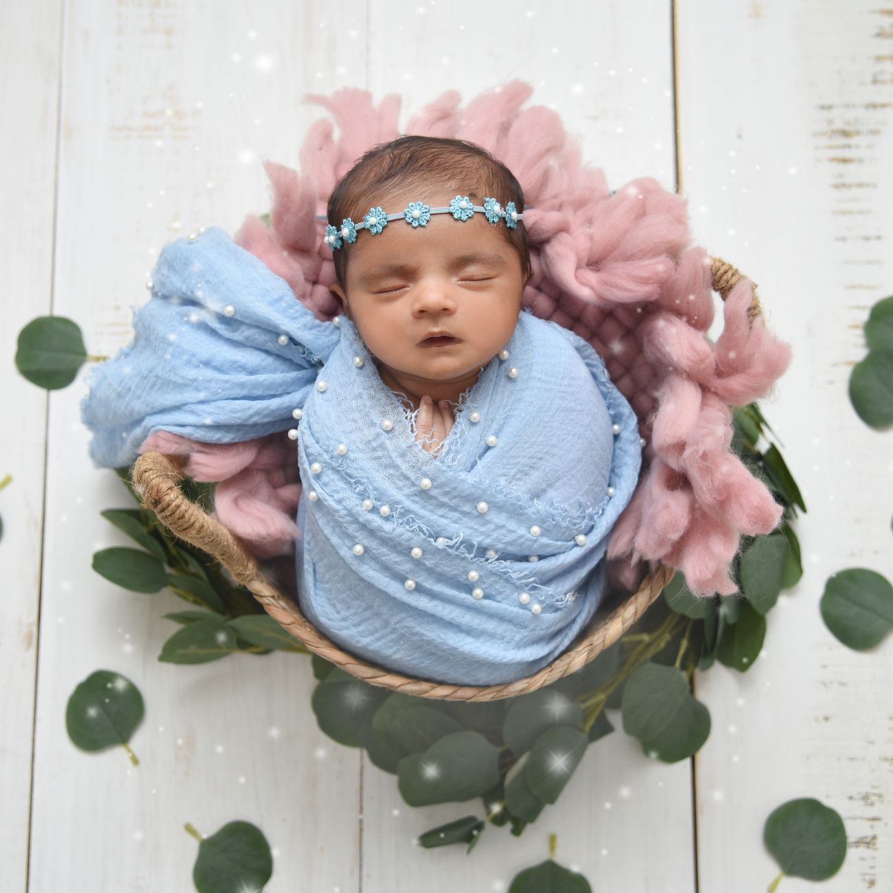 A newborn sleeping peacefully in a basket with soft blankets