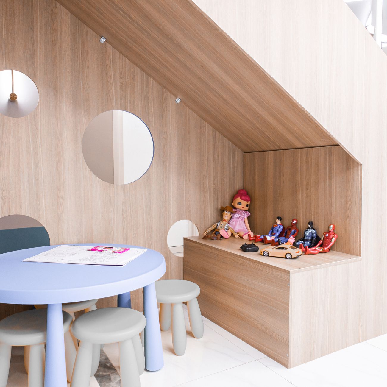 A bright playroom with a round table, small stools and toys