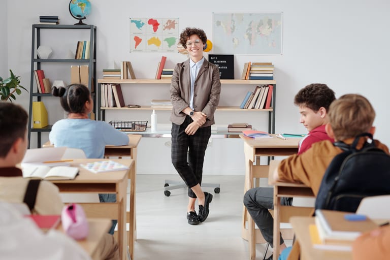 Teacher welcoming children in a bright classroom