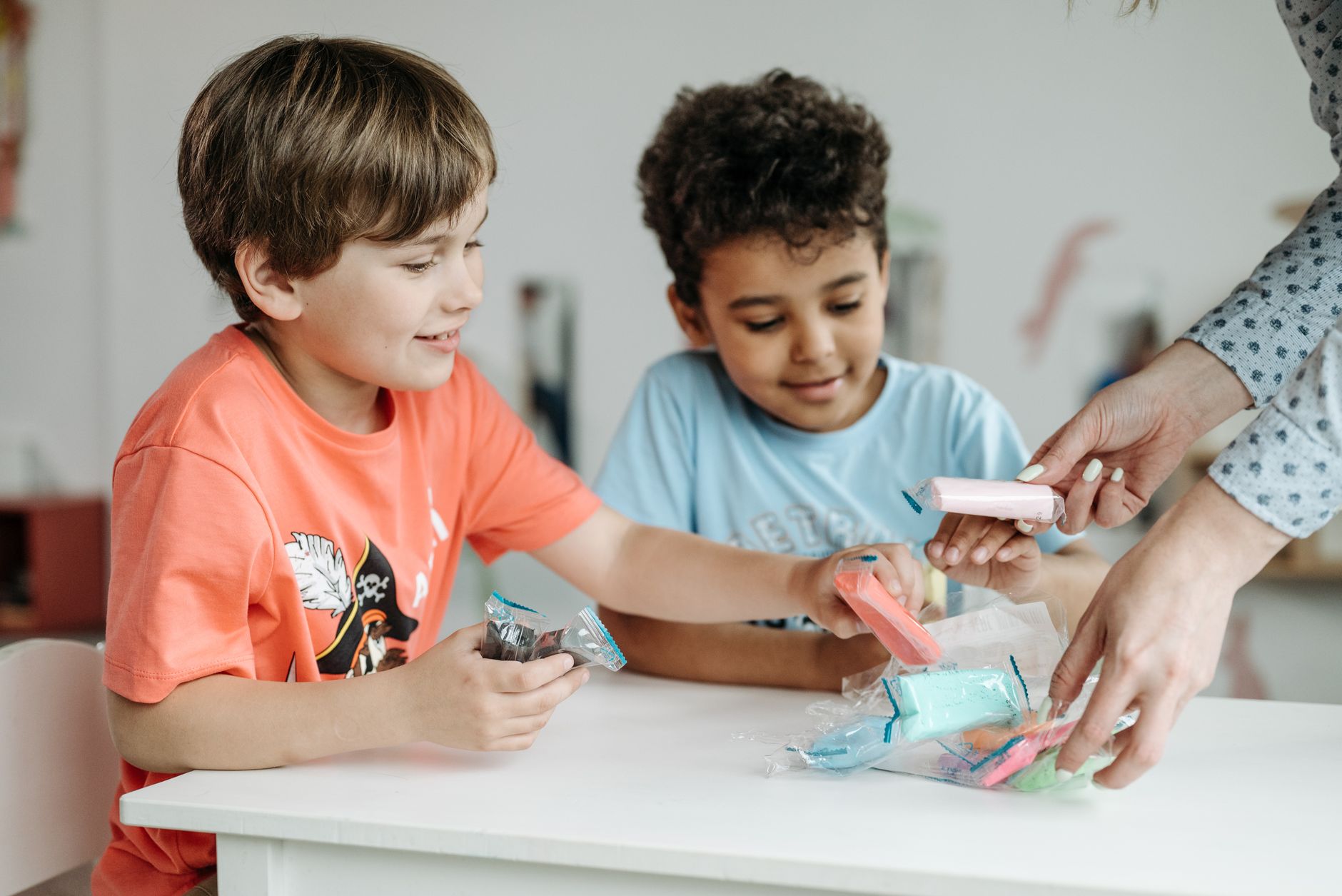 Two kids enjoying creative fun with colorful clay during a playful learning session.