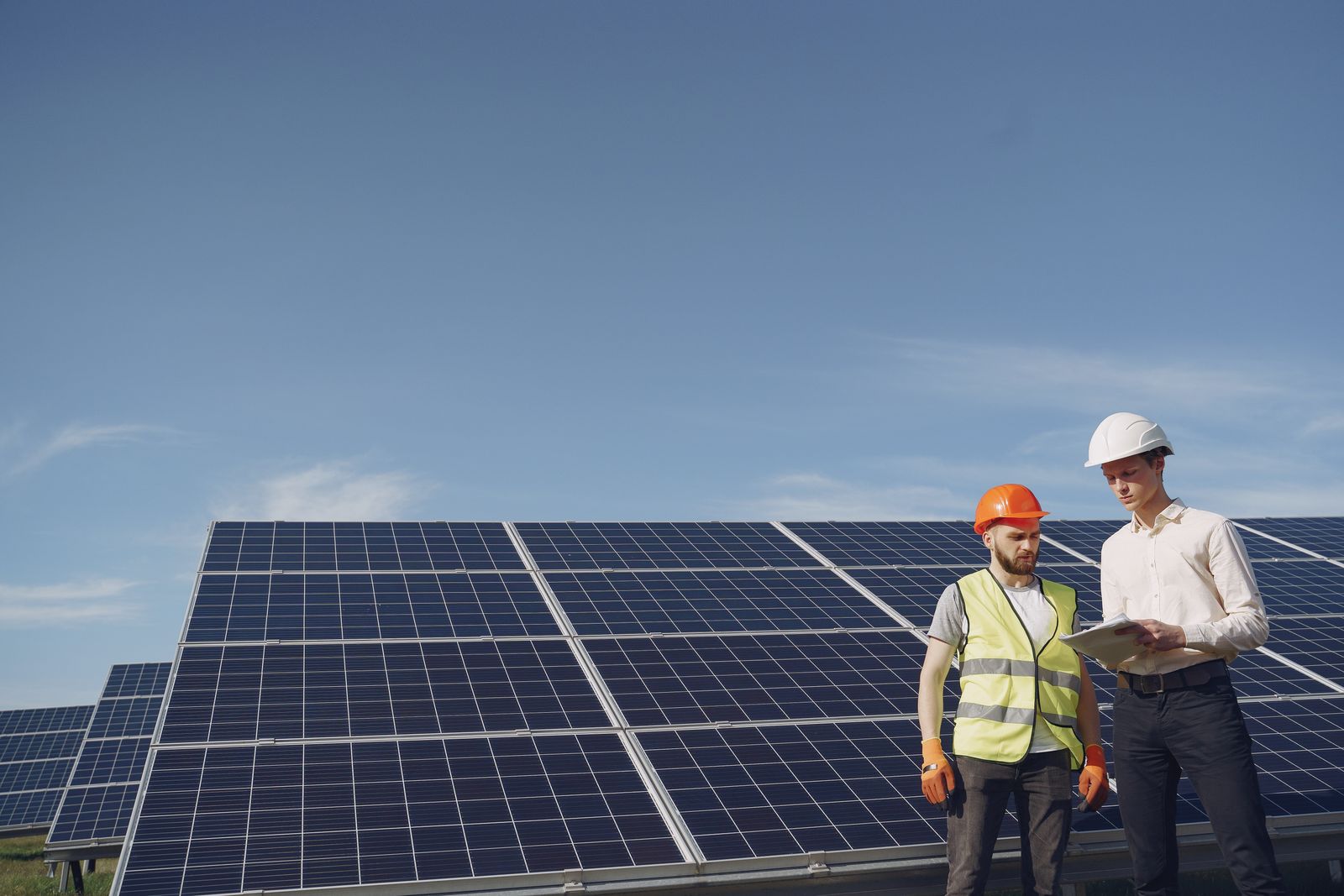 Electricians reviewing plans at a solar panel array